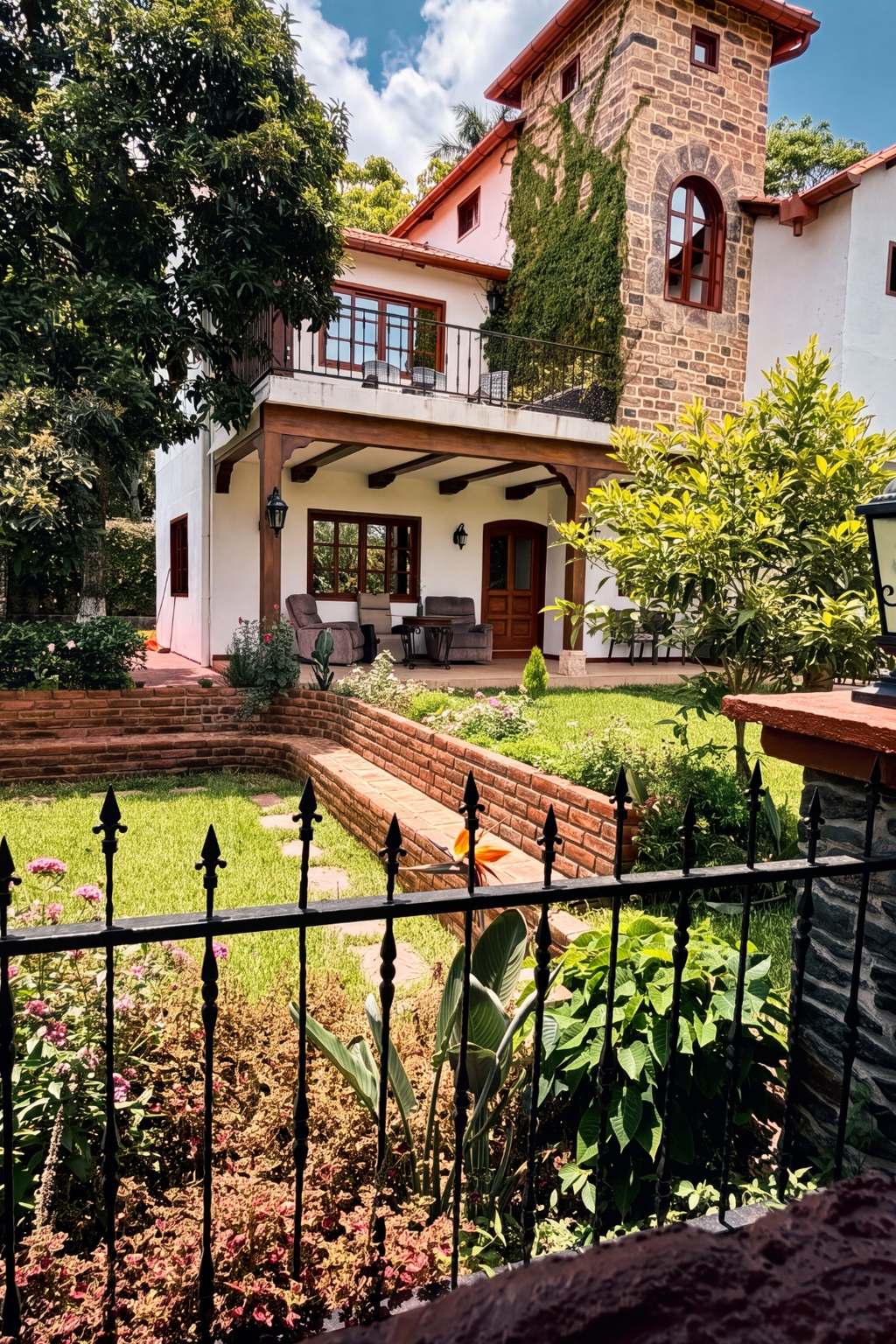 Fachada de Villa Toscana con su torre de piedra cubierta de hiedra