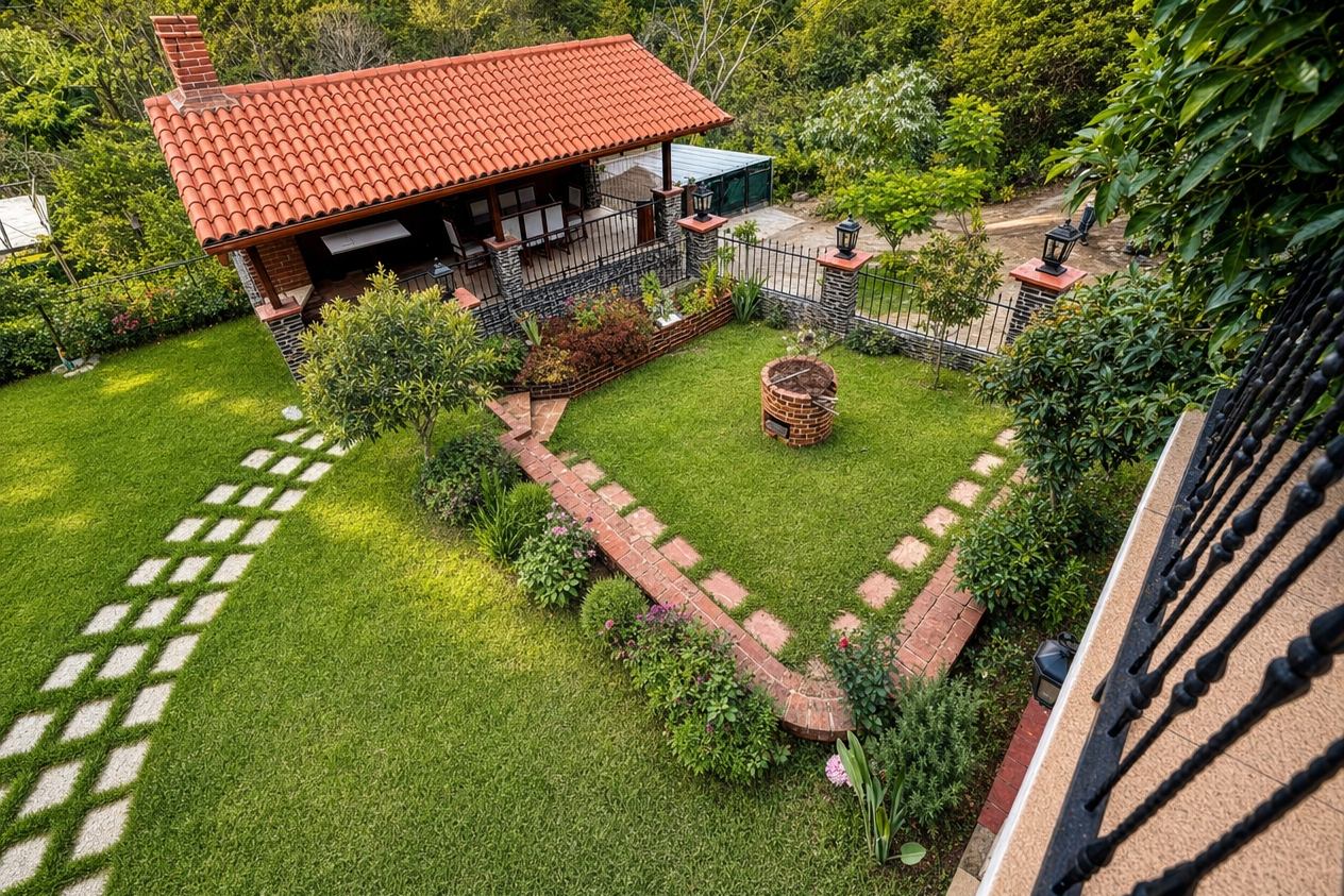 Jardín de la villa con la ramada de teja de barro y la montaña al fondo