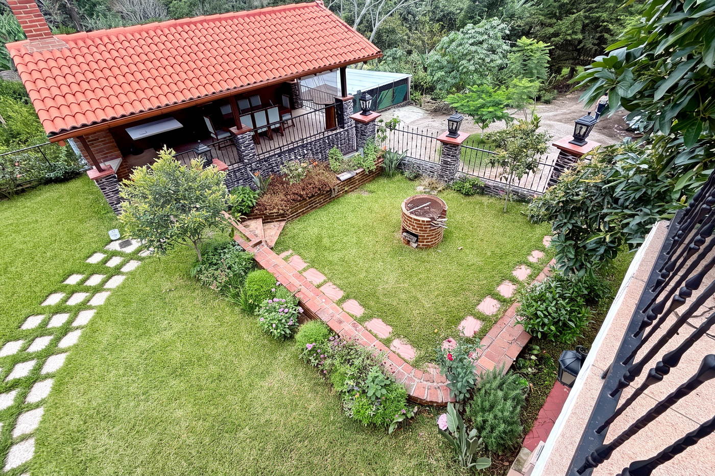 Vista elevada del jardín con la geometría de los jardineros de ladrillo alrededor del césped